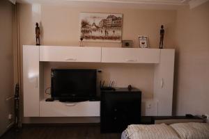 a living room with a tv on a white wall at Central apartments Pleven in Pleven