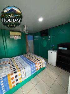 a bedroom with a bed with a happy holiday sign on the wall at Holiday San Jorge in Fortuna