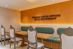 a dining room with tables and chairs and a sign at Casa Stella Rooms in Cartagena de Indias