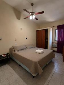a bedroom with a bed with a ceiling fan at KIN Hotel in Villa Carlos Paz