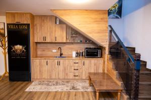 a kitchen with wooden cabinets and a stair case at Villa Loni in Pozharan