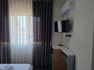 a hotel room with a bed and a television at TRIUMPH rooms and apartment in Vlorë