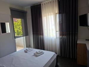 a bedroom with a bed with two towels on it at TRIUMPH rooms and apartment in Vlorë