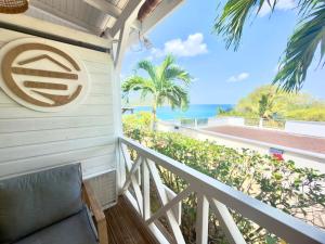 a balcony with a chair and a view of the ocean at La p’tite barque Antillaise in Deshaies