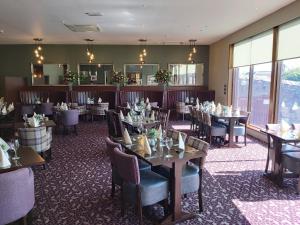 a dining room with tables and chairs and windows at The Strathearn Hotel in Fife