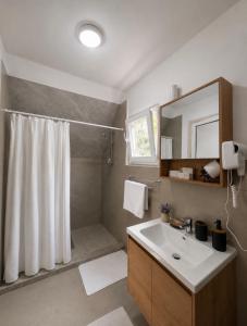 a bathroom with a shower and a white sink at Guest house Panorama in Koman