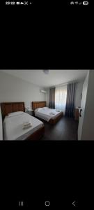 a hotel room with two beds and a window at TRIUMPH rooms and apartment in Vlorë