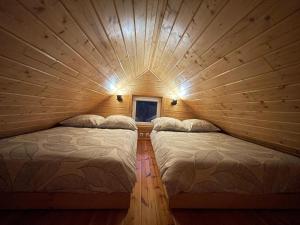 a bedroom with two beds in a log cabin at Chill House Sedranki in Olecko