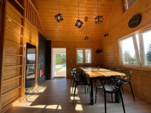 a dining room with a wooden table and chairs at Chill House Sedranki in Olecko