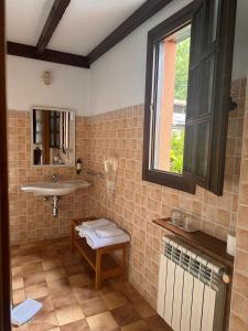 a bathroom with a sink and a mirror and a window at El Mirador de Deva in Deva