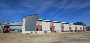 a large white and red building with a parking lot at Super 8 by Wyndham O'Fallon MO/St. Louis Area in O'Fallon
