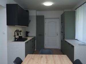 a kitchen with a wooden table and a sink at Popelucha in Lomnice nad Popelkou
