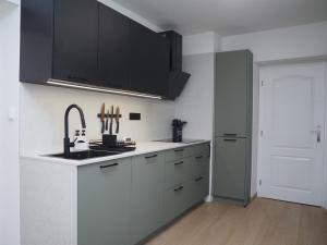 a kitchen with black and white cabinets and a sink at Popelucha in Lomnice nad Popelkou +31 photos