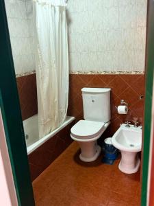 a bathroom with a toilet and a tub and a sink at Casa familiar in Corrientes +9 photos