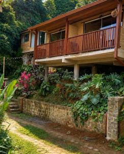 a house with a wooden deck and some plants at Chalés Mar & Mata Paraty in Paraty