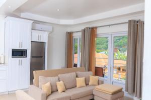 a living room with a couch and a large window at Agape Suites-Room 3- 1st Floor in Soufrière
