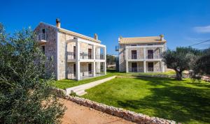 une grande maison en pierre avec une cour en face de celle-ci dans l'établissement Green Hill, à Valanidorachi