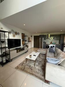 a living room with a couch and a table at Cozy Abode by Embassy Gardens in Cantonments