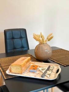 a plate with a loaf of bread and a vase on a table at STV Royal Apartments 3 in Areopoli
