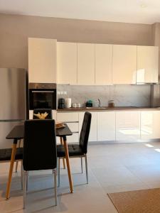 a kitchen with white cabinets and a table and chairs at STV Royal Apartments 3 in Areopoli +26 photos