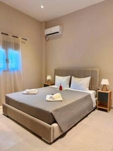 a bedroom with a large bed with two towels on it at STV Royal Apartments 3 in Areopoli