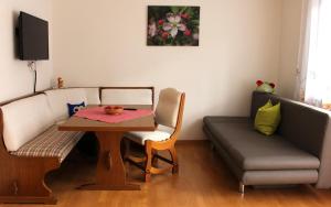 un soggiorno con tavolo e divano di Villa Malus a Castelbello