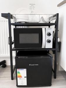 a microwave on top of a cart with a box at UNLIMITED-PEACE PRIVATE STUDIO APARTMENTs in Weston-super-Mare