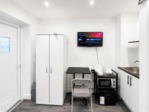 a kitchen with a table and a tv on the wall at UNLIMITED-PEACE PRIVATE STUDIO APARTMENTs in Weston-super-Mare