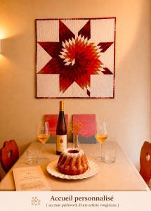 a table with a bottle of wine and a cake at La Terrasse du Tonnelier - 92m2 - plein centre médiéval - sauna - terrasse 20m2 - garage in Kaysersberg