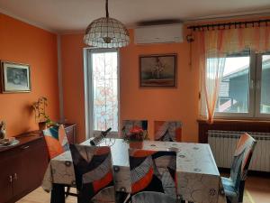 a dining room with orange walls and a table and chairs at Apartment Arcadia in Ozalj