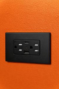 an electrical outlet on an orange wall at Casa Stella Rooms in Cartagena de Indias