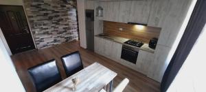 a small kitchen with a wooden table and a stove at New Grey Apartament in Reghin