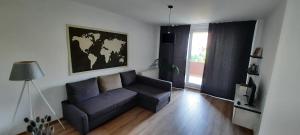 a living room with a blue couch and a window at New Grey Apartament in Reghin