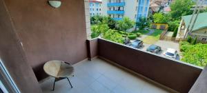 a balcony with a chair and a view of a street at New Grey Apartament in Reghin