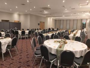 a room filled with tables and chairs with white linens at The Strathearn Hotel in Fife