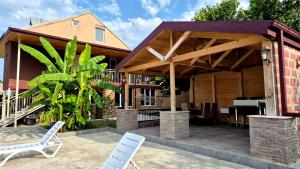 a pavilion with chairs and a table on a patio at Busheti Home in Telavi