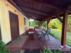 a wooden patio with a table and a bench on it at Domek wakacyjny agroturystyka, Długie Grodzieckie 10 in Wszebory