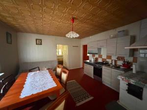 a kitchen with a wooden table and a kitchen with a stove at Domek wakacyjny agroturystyka, Długie Grodzieckie 10 in Wszebory +14 photos