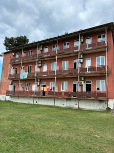 a red brick building with a grass field in front of it at Tolia in Ureki