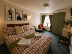 a hotel room with a bed and a chair at Cherish Lewis Sea View Hotel in Blackpool +25 photos