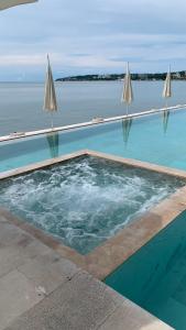a swimming pool with umbrellas next to the water at Bantay 5f in Bucerías