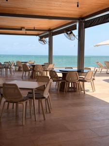 a restaurant with tables and chairs and the ocean at Bantay 5f in Bucerías