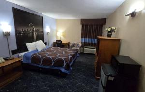 a hotel room with a bed and a television at Super 8 by Wyndham O'Fallon MO/St. Louis Area in O'Fallon