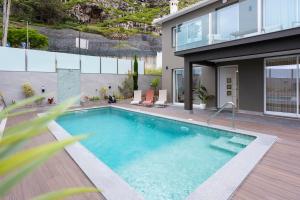 a swimming pool in front of a house at Villa Machim - Heated Pool - View in Machico