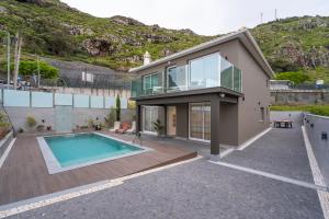 a house with a swimming pool in the backyard at Villa Machim - Heated Pool - View in Machico