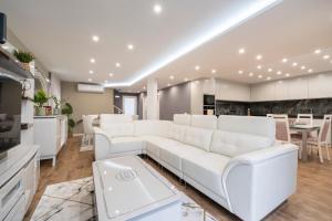a living room with a white couch and a table at Villa Machim - Heated Pool - View in Machico