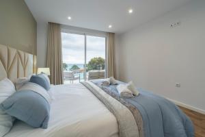 a bedroom with a large bed with a large window at Villa Machim - Heated Pool - View in Machico +54 photos