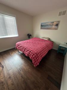 a bedroom with a bed with a red bedspread at Quiet Room 2 in kitchener in Kitchener