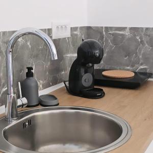a kitchen sink with a coffee maker on a counter at FOREST apartments in Bijela