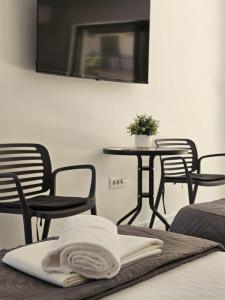 a bed with a towel on a table and chairs at FOREST apartments in Bijela